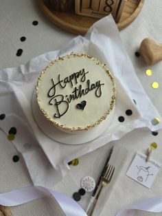 a birthday cake sitting on top of a table next to confetti and ribbons