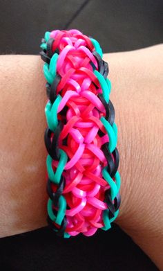 a close up of a person's arm wearing a bracelet with different colored links