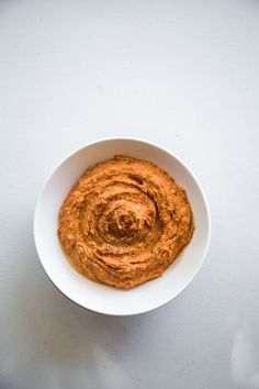 a white bowl filled with hummus on top of a table