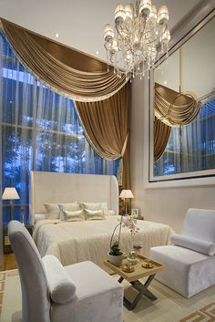 a living room filled with furniture and a chandelier hanging from the side of a window