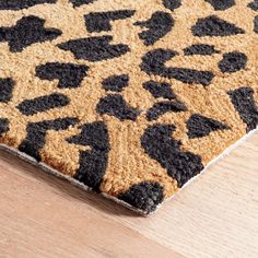 a brown and black rug on top of a wooden floor