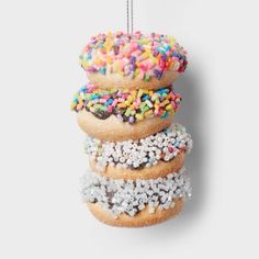 three donuts with sprinkles hanging from strings