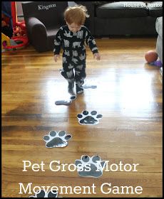 a little boy standing on top of a wooden floor next to a dog paw print