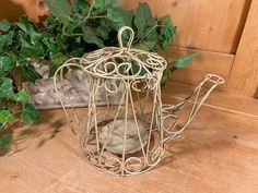 a metal watering can sitting on top of a wooden table