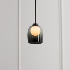 a black and white light hanging from a ceiling fixture in a room with white walls