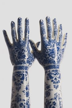 two blue and white hand sculptures are shown