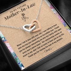 a mother - in - law necklace with two interlocked hearts is displayed inside a box