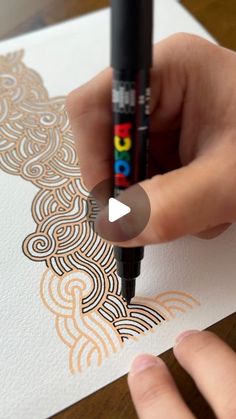 someone is drawing on paper with a marker