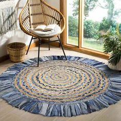 a round rug with blue, yellow and white colors on the floor next to a chair