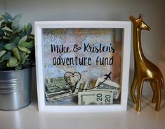 a giraffe figurine sitting next to a framed sign that says mike and kristen's adventure fund