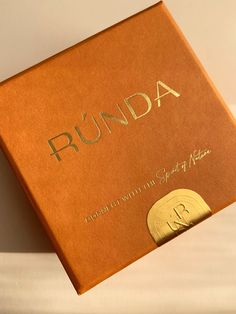 an open book with the word runda written in gold foil on it's cover