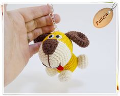 a crocheted dog keychain being held by a person's hand