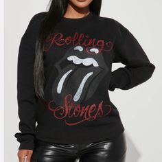 The Rolling Stones Sweatshirt Washed Black Cotton-Blend Fleece. This Cozy, Lightly Distressed Style Features "Rolling Stones Tongue Logo With Distressed Lettering Paired With A Red Glitter! Rib-Knit Crewneck And Cuffs. Drop Shoulders. Pulls Over. 50% Cotton, 50% Polyester. New Made In U.S. The Rolling Stones Black Washed Graphic Sweatshirt Winter Crew Neck Tops For Night Out, Black Graphic Print Top For Fall, Black Long Sleeve T-shirt For Night Out, Black Graphic Print Top For Winter, Fall Letter Print Top For Night Out, Relaxed Fit Long Sleeve Top For Night Out, Black Fitted Graphic Print Sweatshirt, Fitted Black Graphic Sweatshirt, Edgy Letter Print Top For Fall