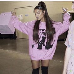 two girls in pink sweaters and black boots are standing next to each other with their hands on their hips