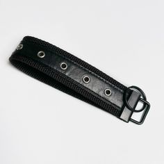 a black leather belt with metal buckles on a white background, close up view