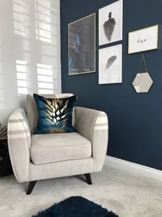 a living room with blue walls and pictures on the wall, including a white chair