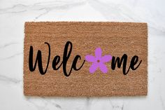 a welcome mat with an easter egg painted on it and the word welcome written in black