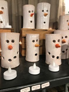 several white vases with holes in them sitting on a shelf next to each other