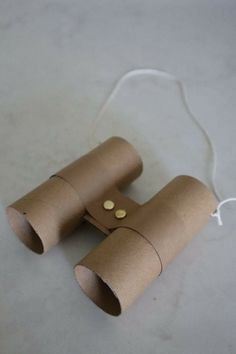 two rolls of toilet paper with buttons attached to the ends, sitting on a white surface