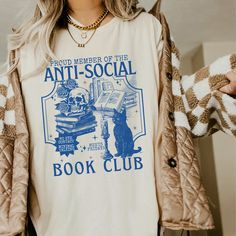 Get ready to be OBSESSED with your new book club shirt. It's the cutest and most trendy way to combine all those important trendy light academia and retrovibes! This is the perfect book lover shirt!  * Q U I C K * F A C T S * ✺  All shirts are UNISEX ✺  100%  ringspun cotton (fiber content may vary for different colors) ✺  Soft-washed, garment-dyed fabric brings extra coziness ✺  Wash and dry normally (on cool for best results) ✺  Sewn-in twill label * S I Z I N G * ✺ For an oversized fit, select two or three sizes up from your normal size ✺ Model is wearing size L  ✺ Sizing runs true to size ✺ Relaxed fit ✺ Most women find their typical size works best, since they are meant to fit a touch loose ✺ See Size guide and fit in images          * S H I P P I N G * T I M E S * ✺ Our items are ind Books Shirt, Book Graphic Tees, Book T Shirts, Book Club Shirt, Book Shirt, Bookish Art, Bookish Merch, Book Clothes, Book Tshirts