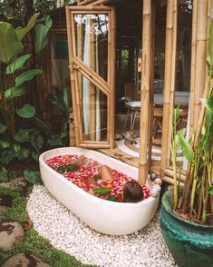 a baby in a bathtub surrounded by plants