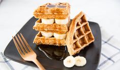 waffles with bananas and syrup on a black plate