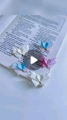 an open book with some origami pieces on top of it and the pages are folded in half