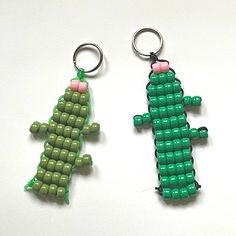 two green and pink beaded keychains sitting next to each other on a white surface