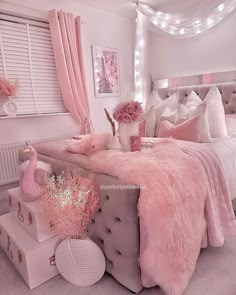 a bedroom decorated in pink and white with lights on the headboard, bedding, rugs and pillows