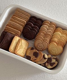 a white tray filled with cookies and cookies on top of a table next to a wall