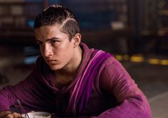 a young man sitting at a table with a bowl of soup in front of him