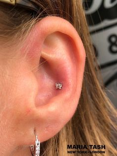 a close up of a person wearing a pair of ear piercings