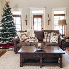 a living room filled with furniture and a christmas tree in the middle of the room