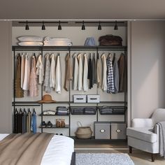 an organized closet with clothes hanging on the wall and a chair sitting in front of it