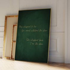 a green chalkboard with gold writing on it in front of a white wall and wooden floor