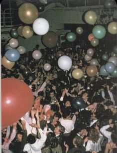 a large group of people at a party with balloons