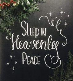 a chalkboard with the words sleep in heavenly peace written on it, surrounded by evergreen branches