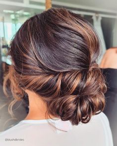 a woman with brown hair in a low bun