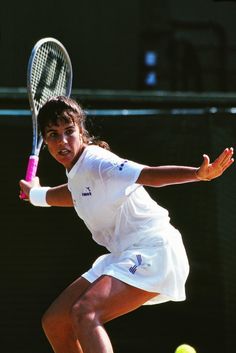 a tennis player in action on the court with her racket and ball behind her