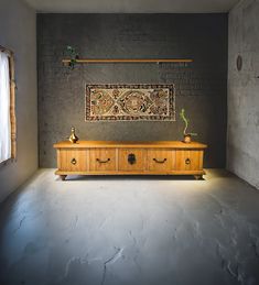 a large wooden dresser sitting in the middle of a room next to a brick wall