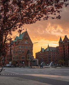 the sun is setting in front of some buildings