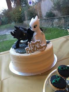 a birthday cake and cupcakes on a table