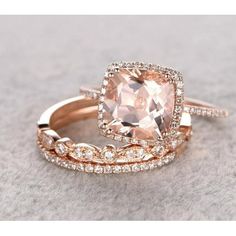 two wedding rings with an morganite surrounded by white and rose gold diamond bands on a gray surface