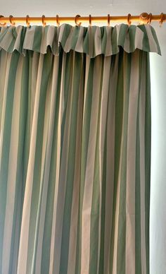 green and white striped curtains hanging on a curtain rod