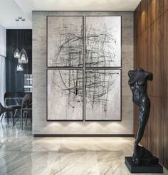 a large abstract painting hangs on the wall next to a sculpture in front of a dining room table