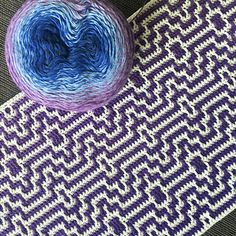 a ball of yarn sitting on top of a purple and white rug