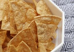 a white bowl filled with tortilla chips on top of a blue and white towel