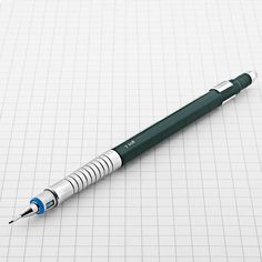 a green and white pen sitting on top of a piece of paper