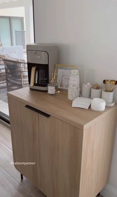 a wooden cabinet sitting next to a window with a coffee maker on top of it