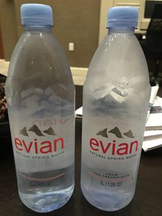 two bottled water bottles sitting on top of a table